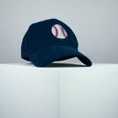 a baseball cap sitting on top of a white pedestal