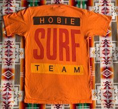 Vintage 80s Hobie Surf Team t shirt. Made in USA. Single stitch, tube knit (no side seams). 100% cotton. Graphics on the front and back. In very good vintage condition. No holes or stains. Size marked medium but please refer to the actual measurements: 19 inches from pit to pit measured lying flat, 16 1/2 inches across the shoulders, sleeve length is 8 inches and the overall length is 29 inches. Please review all photos, descriptions and measurements. Feel free to ask questions. All sales final. Vintage Cotton Crew T-shirt, Vintage Cotton Crew Neck T-shirt, Retro Cotton Crew Neck T-shirt, Vintage Logo Print T-shirt, Retro Cotton T-shirt For Surfing, Team T Shirt, Surf Tee, Team T Shirts, Mens Graphic Tee