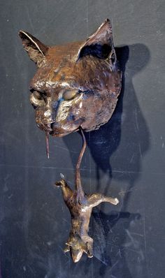 a sculpture of a cat with its head upside down