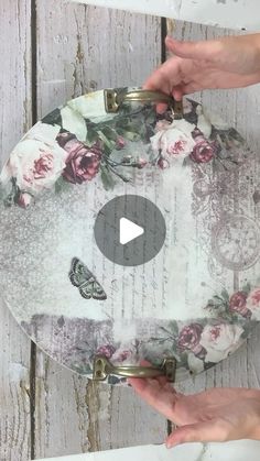 two hands holding onto a floral tray with roses on it and butterflies in the background