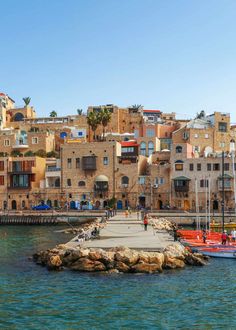 boats are docked in the water next to an old city with stone buildings on it