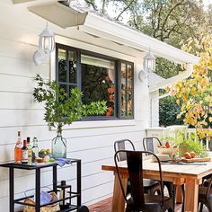 an outdoor dining area with table, chairs and potted plants on the deck outside