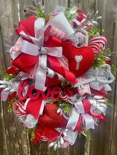 a red and silver heart wreath with the word love on it