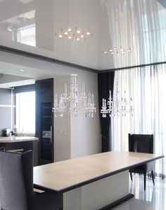 a modern dining room with chandelier hanging from the ceiling