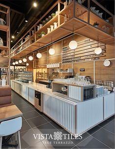 the interior of a restaurant with tables, chairs and shelves filled with dishes on them