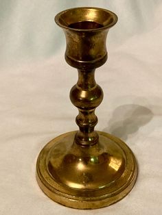 an antique brass candle holder on a white background