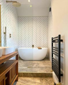 a bathroom with two sinks and a bathtub next to a wall mounted heater