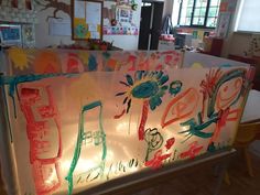 an art display with children's drawings and lights in the back room at school