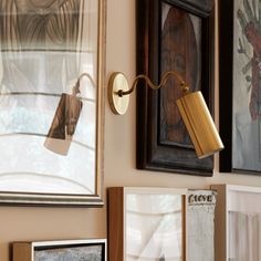 a wall mounted light next to some framed pictures