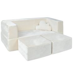 a white couch and ottoman sitting next to each other on a white surface with no one in it