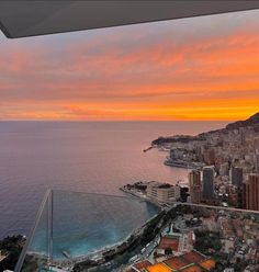 an aerial view of a city and the ocean at sunset