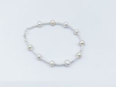 This enchanting bracelet is the epitome of versatile charm, making it the perfect choice for bridesmaids, everyday wear, and special occasions. Each lustrous freshwater pearl exudes natural beauty, handpicked for their radiant glow and refined grace. Interspersed among these pearls, the sterling silver beads add a touch of contemporary sophistication, creating a harmonious blend of classic and modern design. Elegance meets versatility as this bracelet effortlessly complements any attire. Whether Delicate Adjustable Beaded Bracelets For Bridesmaids, Adjustable Delicate Beaded Bracelets For Bridesmaids, Pearl Charm Bracelets For Bridesmaid Gift, Pearl Charm Bracelets For Bridesmaids, Adjustable Pearl Charm Jewelry For Bridesmaid Gift, Classic Sterling Silver Charm Bracelet For Wedding, Adjustable Pearl Charm Bracelet For Bridesmaids, Adjustable Pearl Bracelet For Bridesmaids, Adjustable Silver Beaded Bracelets For Bridesmaid Gift