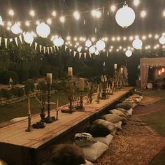 a long table is set up with candles and decorations for an outdoor wedding or party