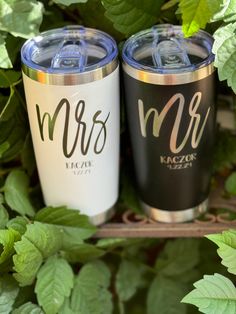 two personalized tumblers sitting next to each other in front of green leaves and plants