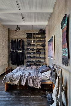 a bed sitting in a bedroom next to a wall mounted rack with clothes on it