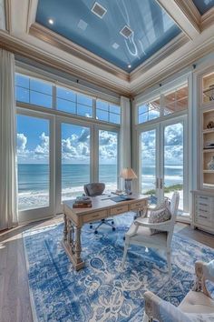 a living room filled with furniture and large windows overlooking the ocean in front of it