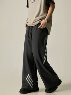 Effortlessly combine comfort and style with these Wide-Leg Drawstring Track Pants. Featuring a stylish contrast stripe design and a convenient drawstring waist, these pants offer a relaxed fit and modern look. Perfect for workouts or casual days, these pants are a must-have addition to your wardrobe. model: 174cm 61kg M material: 90% polyamide fiber (nylon). 10% polyurethane elastic fiber (spandex) Wide Leg Sweatpants With Side Stripes For Loungewear, Striped Pants With Pockets For Streetwear, Gray Wide Leg Sweatpants With Drawstring, Casual Striped Streetwear Pants, Gray Wide-leg Sweatpants With Drawstring, Casual Wide Leg Sweatpants With Three Stripes, Wide Leg Loungewear Bottoms With Side Stripes, Wide Leg Bottoms With Side Stripes For Loungewear, Casual Striped Bottoms For Streetwear