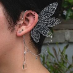 a close up of a person with ear piercings on their ears and behind the ear