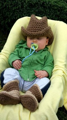 a baby wearing a cowboy hat sitting in a chair