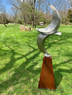 a metal sculpture sitting on top of a green field