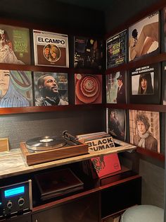 a record player sitting on top of a wooden table next to a shelf filled with records