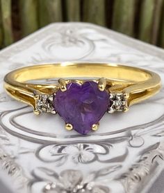 Gorgeous Vintage 10k Yellow Gold HEART AMETHYST Diamond Ring Size 7! * Beautiful vintage estate ring! * Beautiful ring crafted in solid 10k gold with a unique design! * Heart cut center amethyst set into unique style band with natural diamond accents! * Size 7 * Weighs 1.8 grams! Will ship FAST and FREE, in a gift box and fully insured : ) I guarantee item to be exactly as described and pictured. Gold Heart-shaped Diamond Ring With Center Stone, Gold Ring With Gemstone In Heart Cut, Yellow Gold Heart Cut Ring With Accent Stones, Gold Heart Cut Gemstone Ring, Gold Heart Ring With Accent Stones Fine Jewelry, Gold Amethyst Ring With Accent Stones For Anniversary, Gold Heart Cut Diamond Ring With Accent Stones, Gold Diamond Heart Cut Ring With Accent Stones, Gold Heart Ring With Center Stone For Anniversary