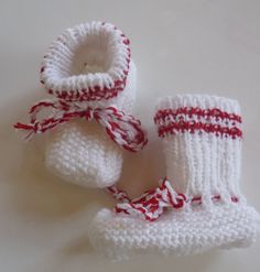 two crocheted baby booties with red and white stripes