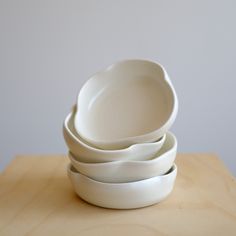 four white bowls stacked on top of each other