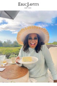 a woman sitting at a table with a plate of food in front of her smiling