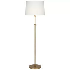 a gold floor lamp with a white shade on the base and a round light fixture