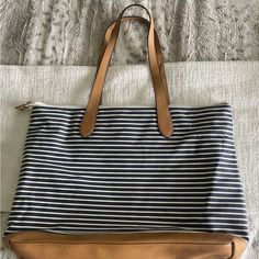 A New Day Tote Navy & White Stripe, Dual Shoulder Straps, A Large Zippered Pocket On The Back(Gold Accents) Two Compartments On The Inside Along With Another Large Zipper Pocket. Travel Shoulder Bag With Striped Lining, Everyday Striped Bags With Leather Handles, Chic Travel Bag With Striped Lining, Travel Bags With Striped Lining, Everyday Use Shoulder Bag With Striped Lining, Everyday Bags With Striped Lining, Chic Daily Use Bags With Striped Lining, White Tote Shoulder Bag With Striped Lining, White Travel Bag With Striped Lining