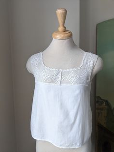 This Antique 1900s/10s white cotton + filet crochet camisole/corset cover would make a beautiful and breezy warm weather top! Drawstring at neckline, otherwise no closures.  Approximate Measurements of Garment laid flat: Bust: exactly 34"underarm to underarm, more like 34 1/2" below that  Waist: 36 1/2" Across bottom, it is 37" length: 17 1/2" from shoulder strap *Shown on 32"-25"-32" mannequin  XS Very good antique condition. Clean and intact overall, though there are a couple of hidden repairs Vintage Summer Crochet Top With Lace Work, Victorian Cotton Tops For Summer, Cotton Crochet Top With Lace Trim For Daywear, Lace Top With Crochet Trim For Daywear, Cotton Crochet Top For Daywear, Vintage Cotton Crochet Trim Top, Vintage Lace Trim Camisole Top, Vintage Lace Trim Camisole Tank Top, Vintage Lace Trim Tank Top