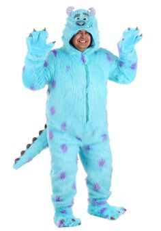 a man in a blue monster costume is standing with his hands up and smiling at the camera