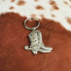 a metal keychain with a cowboy boot design on it's front end