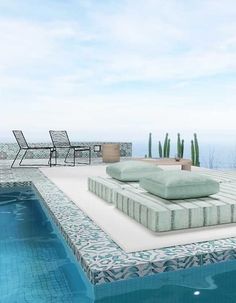 an empty pool with two lounge chairs and a table