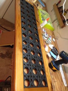 a wooden table topped with lots of clutter next to a power drill and screwdriver