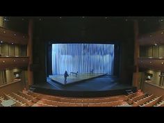 an empty auditorium with a person standing on the stage