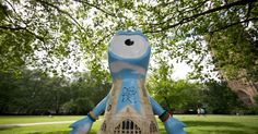 a blue and white bird statue in the middle of a park