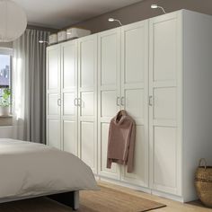 a bedroom with white cabinets and a bed