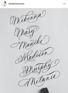 some type of calligraphy that is on the wall in front of a pen and paper