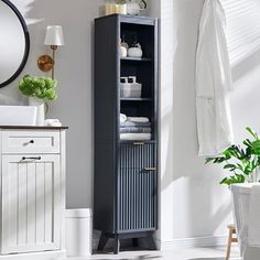 a tall black cabinet in the corner of a room with white walls and flooring