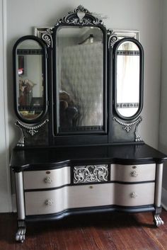 an ornate black and white dresser with mirror