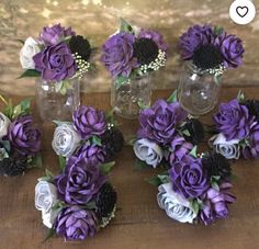 purple and white flowers in glass vases sitting on a wooden table next to each other