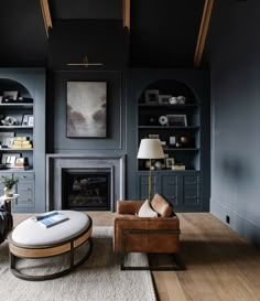 a living room filled with furniture and a fire place next to a book shelf on top of a hard wood floor