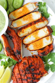 grilled meat with sauce and cucumbers on a plate