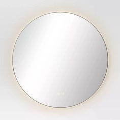 an illuminated round mirror on the wall