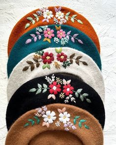 five hats with flowers and leaves on them