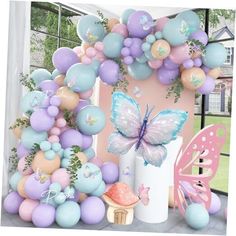 the balloon arch is decorated in pastel colors and features butterflies, flowers, and balloons