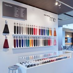 a display in a store filled with lots of different colored bags and umbrellas hanging from the ceiling