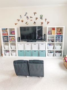 two black chairs sitting in front of a tv on top of a white book shelf